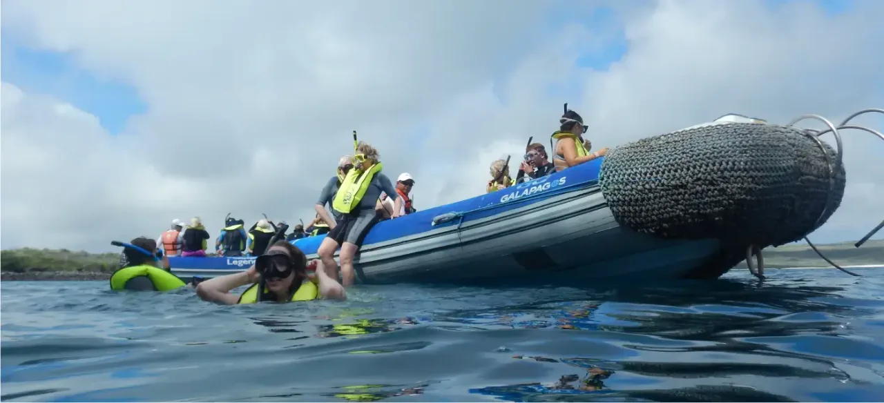 Travelers snorkeling from an inflatable boat in the Galapagos Islands, enjoying a guided marine wildlife adventure in clear ocean waters.