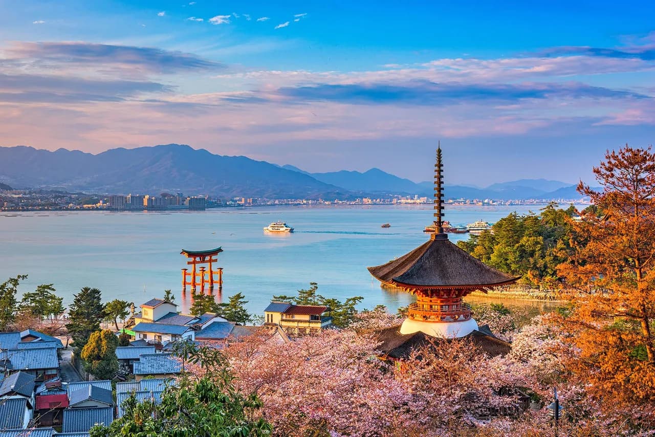 Miyajima Island’s iconic Shinto landmarks framed by cherry blossoms in spring in Hiroshima, Japan./Shutterstock