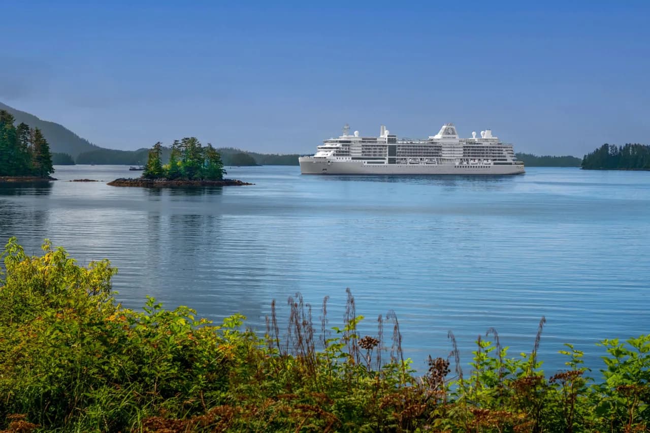 Silversea luxury cruise ship at Sitka, Alaska, framed by green pine-covered islands.
