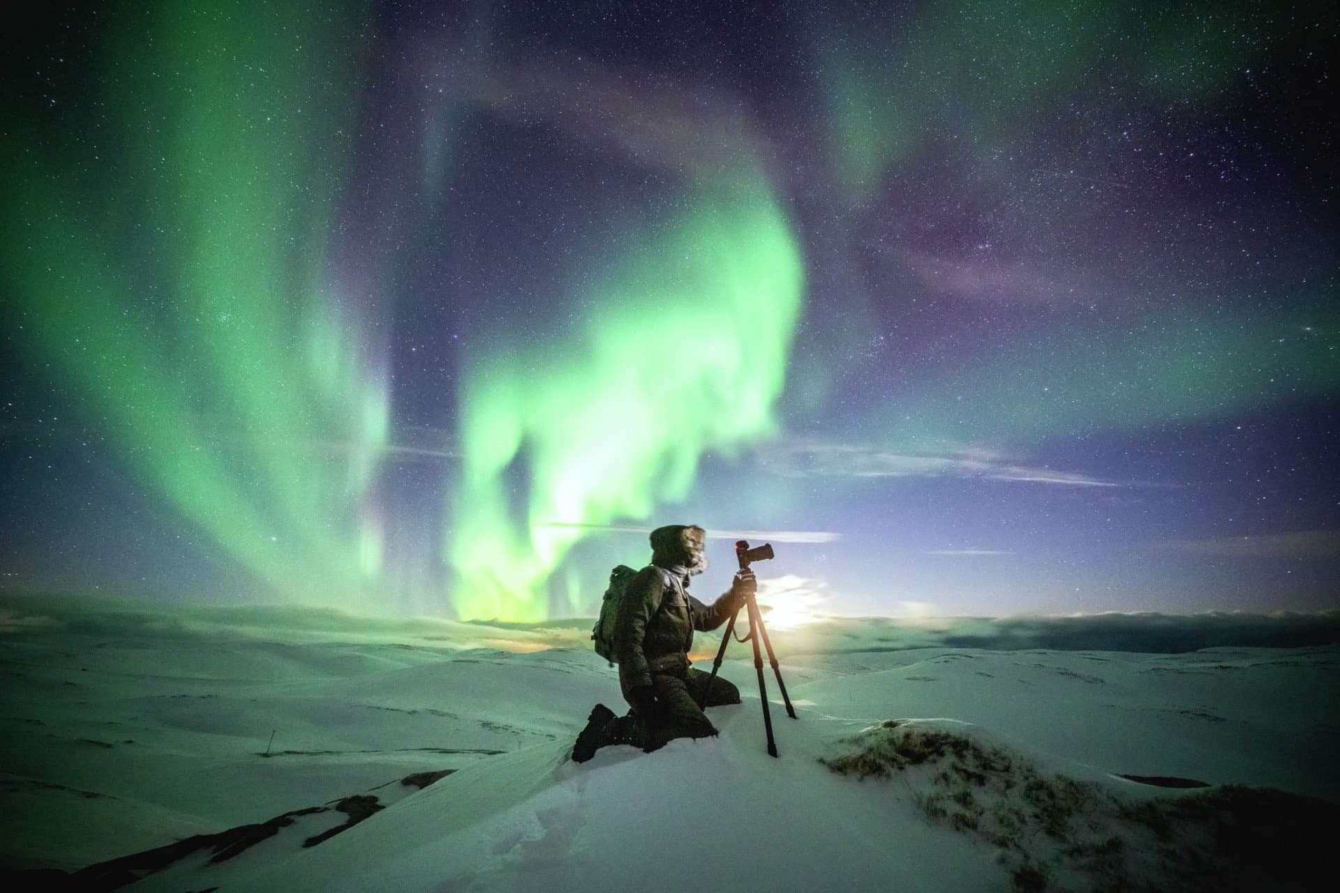 A photographer photographing the Northern Lights in the North Cape, Norway